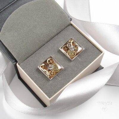 Kwadratowe spinki do mankietów ze srebra z kompozycją trybików zegarków na tle drewna