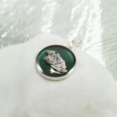 Uroczy wisiorek z mechaniczną żabką na zielonym tle