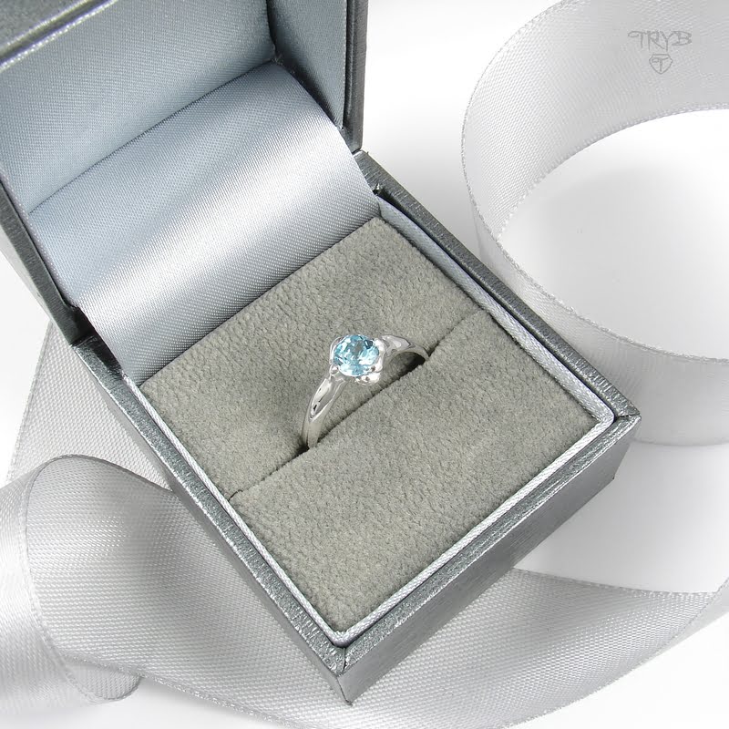 złoty pierścionek w kształcie kocich łapek trzymających kamień